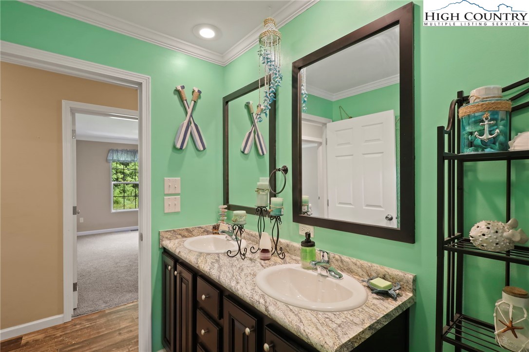 565 Valley Road Spruce Pine, NC 28777 - Photo 29 of 39 a bathroom with a granite countertop sink a mirror and a shower