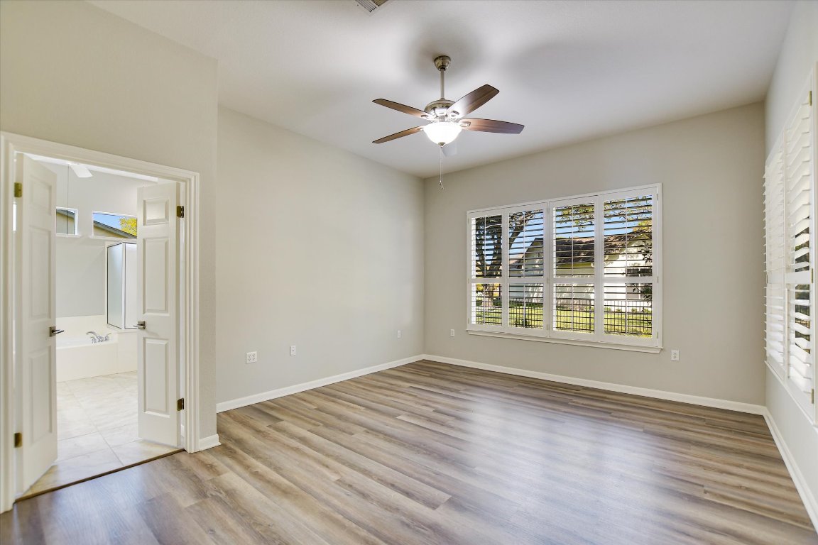 126 Bass Street Georgetown, TX 78633 - Photo 14 of 20 Unfurnished bedroom featuring light wood-style floors, ceiling fan, and ensuite bath