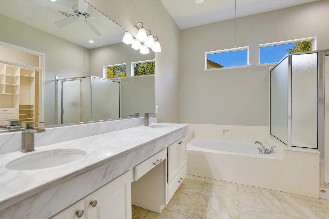 126 Bass Street Georgetown, TX 78633 - Photo 15 of 20 Full bathroom featuring a stall shower, a bath, double vanity, a ceiling fan, and a walk in closet