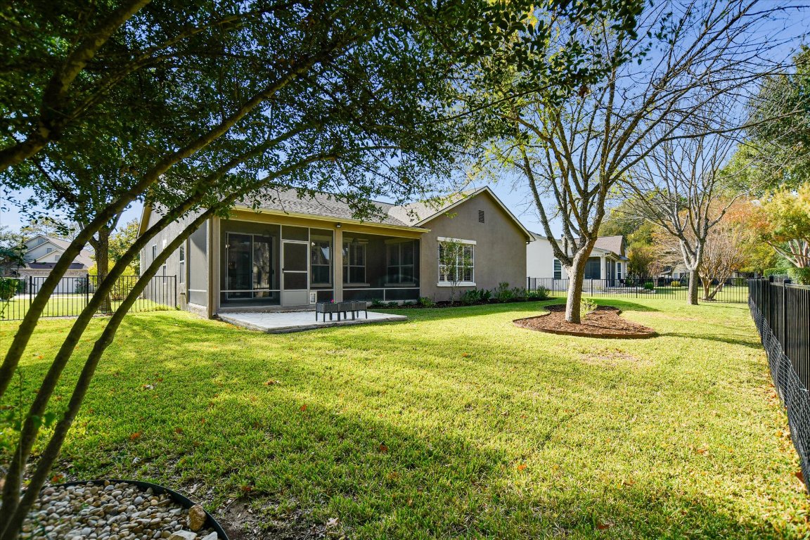 126 Bass Street Georgetown, TX 78633 - Photo 20 of 20 Rear view of house with a fenced backyard, stucco siding, a sunroom, and a patio