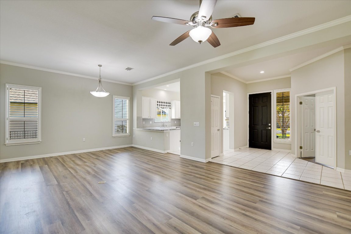 126 Bass Street Georgetown, TX 78633 - Photo 4 of 20 Unfurnished living room with ornamental molding, light wood-type flooring, and ceiling fan