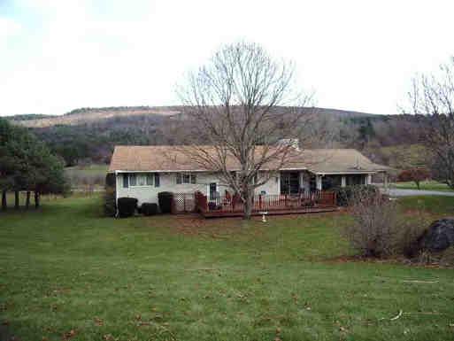 a view of a house with a garden and sitting area