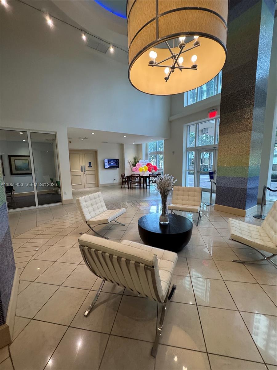 2001 Biscayne Boulevard, Unit 2621 Miami, FL 33137 - Photo 20 of 23 a living room with furniture a dining table and a chandelier