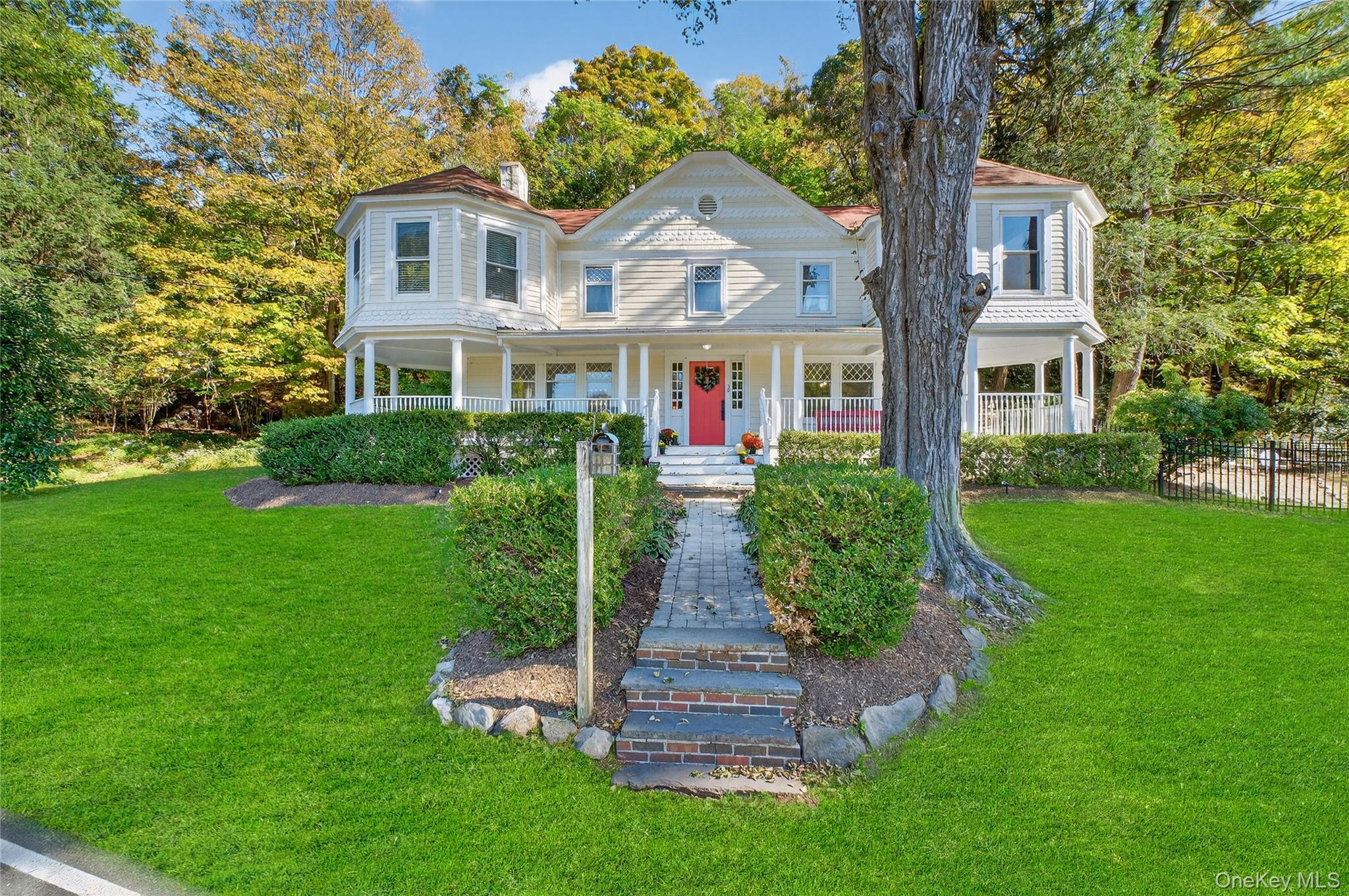 a front view of a house with a yard and trees