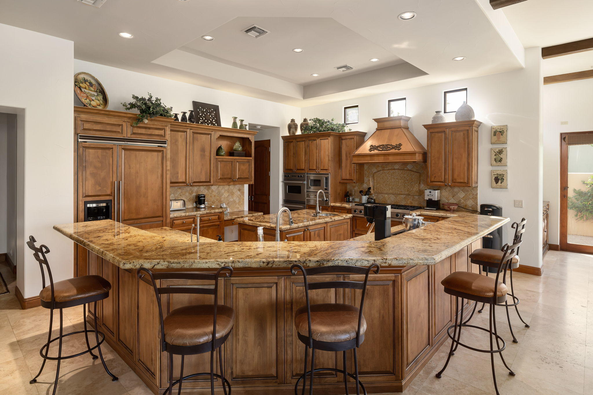 57325 Peninsula Lane La Quinta, CA 92253 - Photo 40 of 66 a kitchen with stainless steel appliances granite countertop a kitchen island and chairs in it