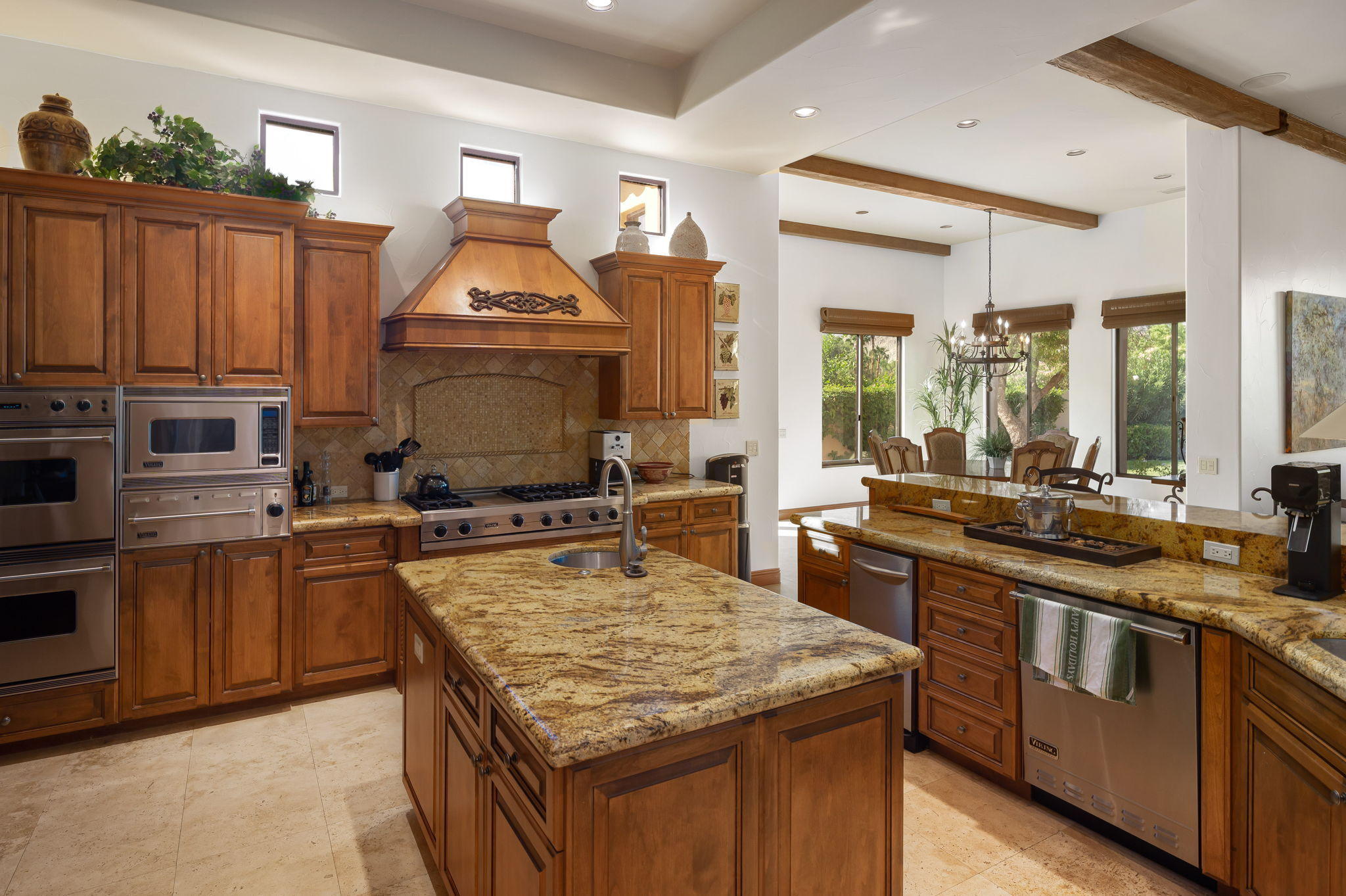 57325 Peninsula Lane La Quinta, CA 92253 - Photo 43 of 66 a kitchen with kitchen island granite countertop wooden cabinets and a stove