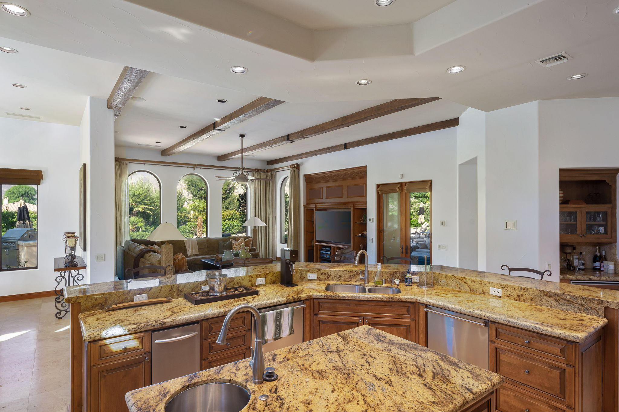 57325 Peninsula Lane La Quinta, CA 92253 - Photo 44 of 66 a large kitchen with kitchen island granite countertop a large window cabinets a sink stainless steel appliances and a large window