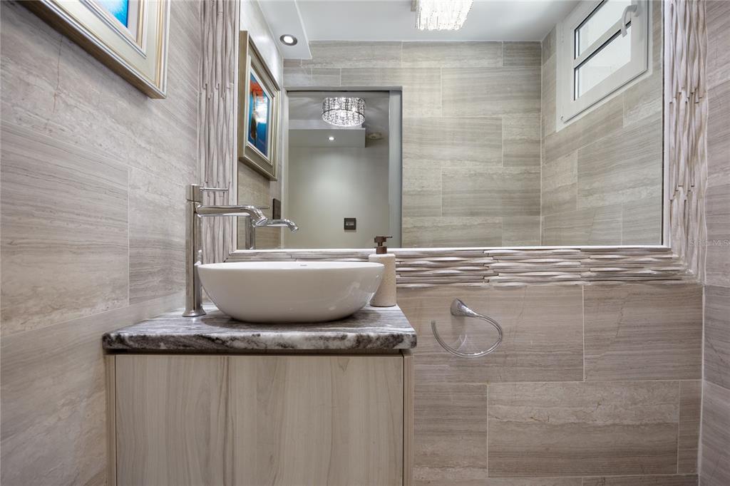 1 Bucaré, Unit 4 San Juan, PR 00913 - Photo 5 of 49 a bathroom with a granite countertop sink a mirror and a bathtub