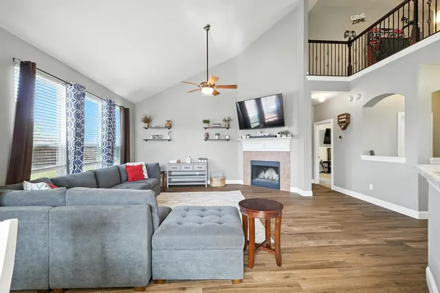 a living room with furniture a fireplace and a flat screen tv