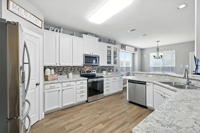 a kitchen with white cabinets and white appliances