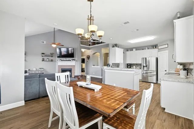a view of a dining room and a kitchen with a table chairs