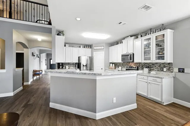 a kitchen with white cabinets and sink