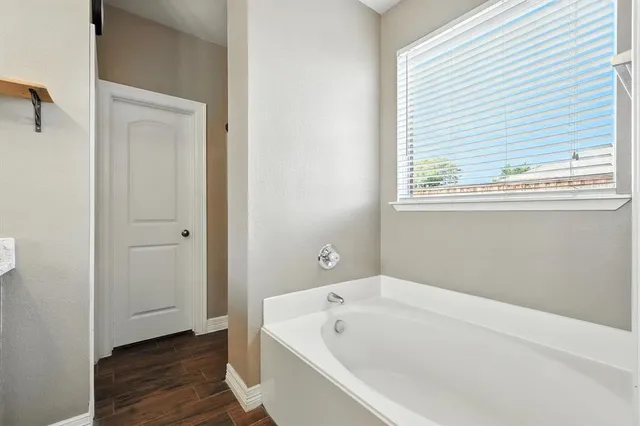 a bathroom with a bathtub and a window
