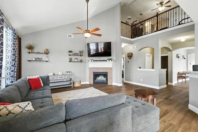 a living room with furniture a flat screen tv and a fireplace