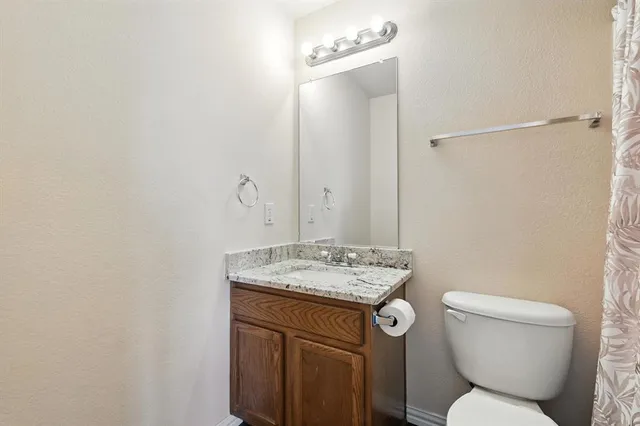 a bathroom with a toilet a sink and a mirror