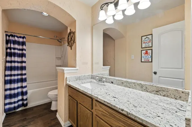 a bathroom with a granite countertop sink mirror vanity and toilet