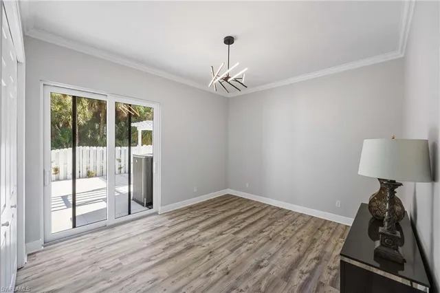a view of a hallway with wooden floor and a chandelier