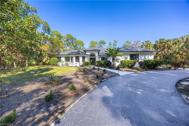 a front view of a house with a yard tree and outdoor seating