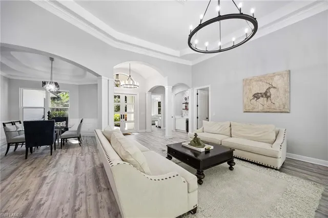 a living room with furniture a dining table and a chandelier