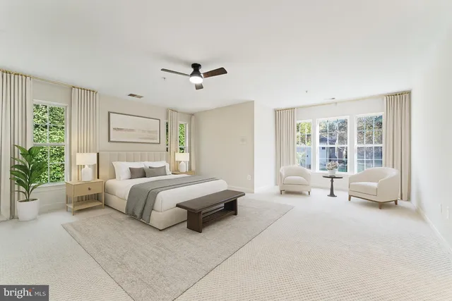 a spacious bedroom with a bed couch and a large window