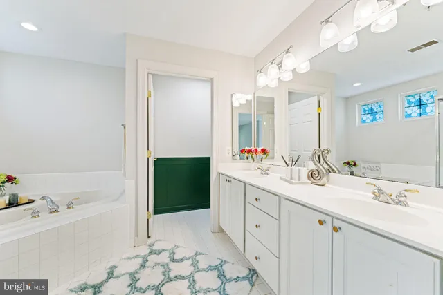 a bathroom with a tub sink and mirror