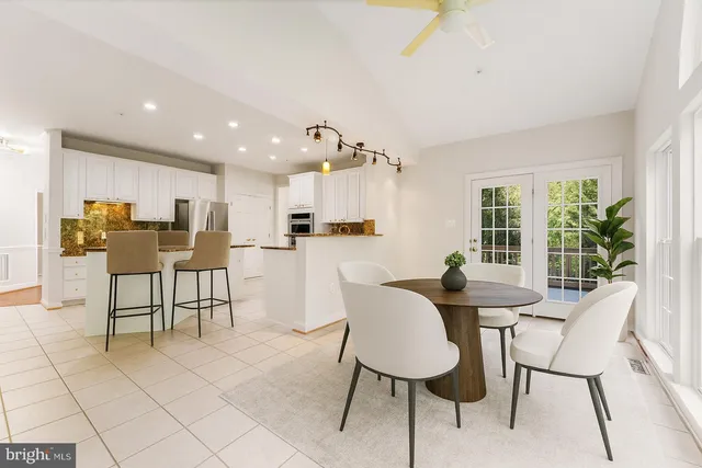 a dining room with furniture and kitchen view