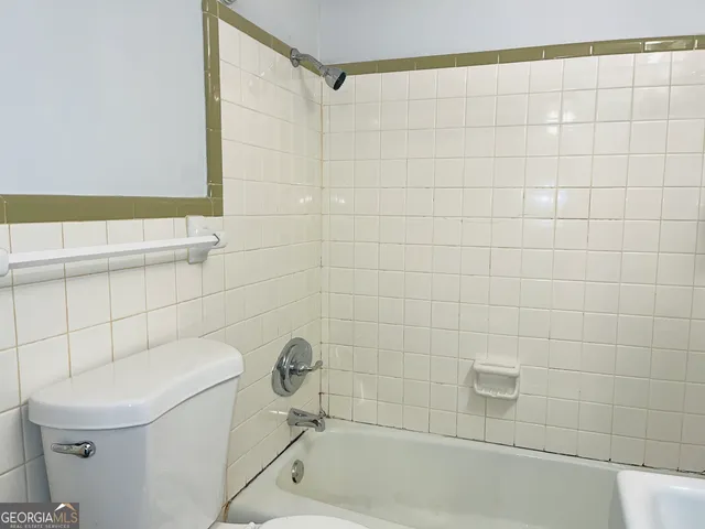 a bath tub sitting next to a white sink and a shower