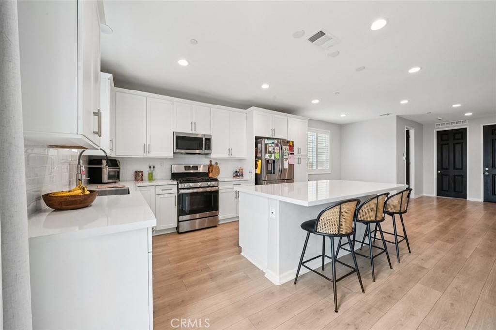 14270 Hercules Street Hesperia, CA 92345 - Photo 18 of 46 a kitchen with granite countertop a table chairs microwave and cabinets