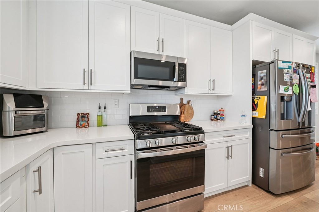 14270 Hercules Street Hesperia, CA 92345 - Photo 19 of 46 a kitchen with stainless steel appliances granite countertop a refrigerator stove and microwave