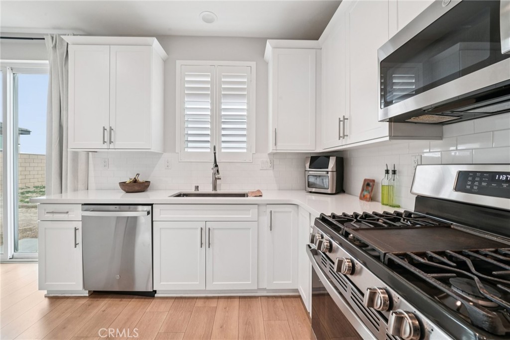 14270 Hercules Street Hesperia, CA 92345 - Photo 21 of 46 a kitchen with stainless steel appliances granite countertop a stove and a white cabinets