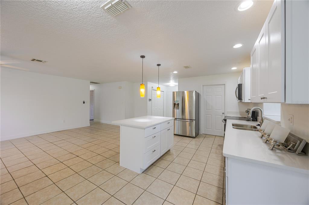495 Orange Avenue St. Cloud, FL 34769 - Photo 11 of 32 a kitchen with a sink cabinets and stainless steel appliances
