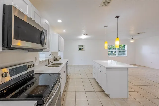 a kitchen with a sink stainless steel appliances and cabinets