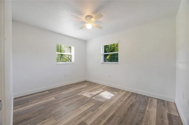 a spacious bathroom with a granite countertop sink a toilet mirror and a bathtub