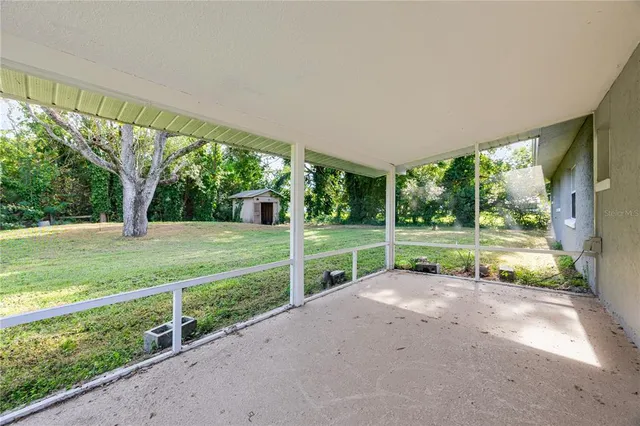 a view of swimming pool with lawn chairs and a big yard
