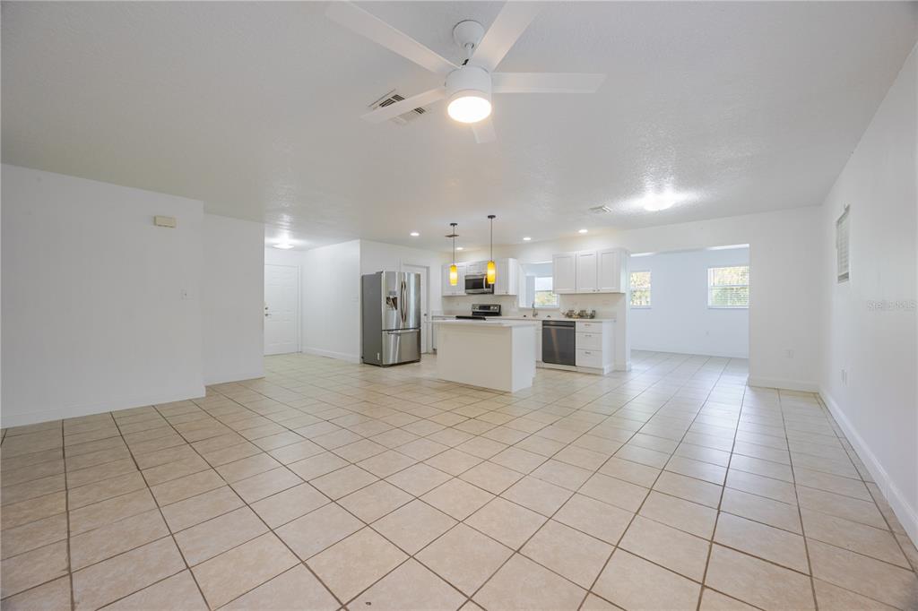 495 Orange Avenue St. Cloud, FL 34769 - Photo 9 of 32 a view of kitchen and empty room with wooden floor
