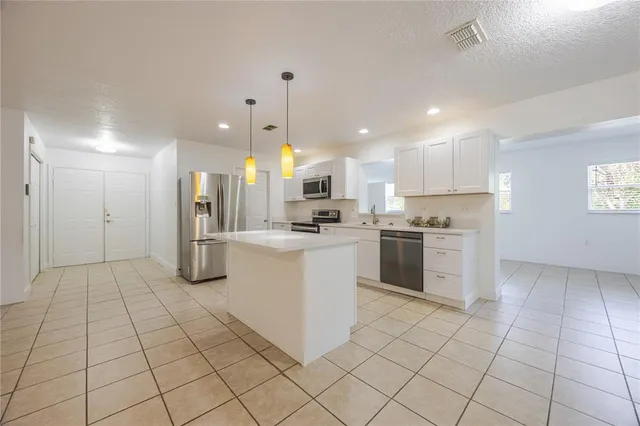 a kitchen with stainless steel appliances kitchen island granite countertop a sink and cabinets