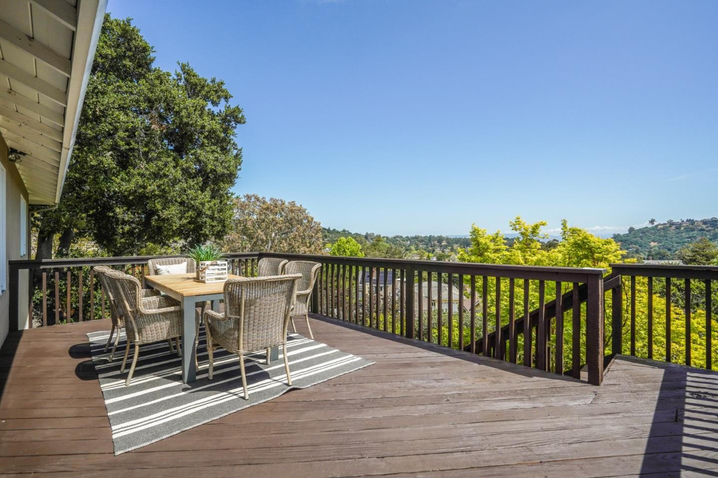a balcony with wooden floor table and chairs