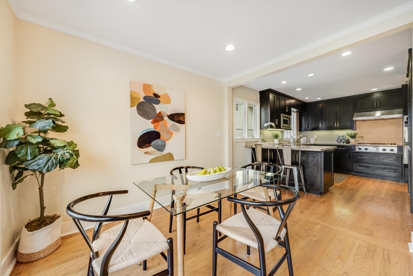2211 Ewell Road Belmont, CA 94002 - Photo 13 of 44 a kitchen with stainless steel appliances kitchen island granite countertop a sink a stove a dining table and chairs with wooden floor