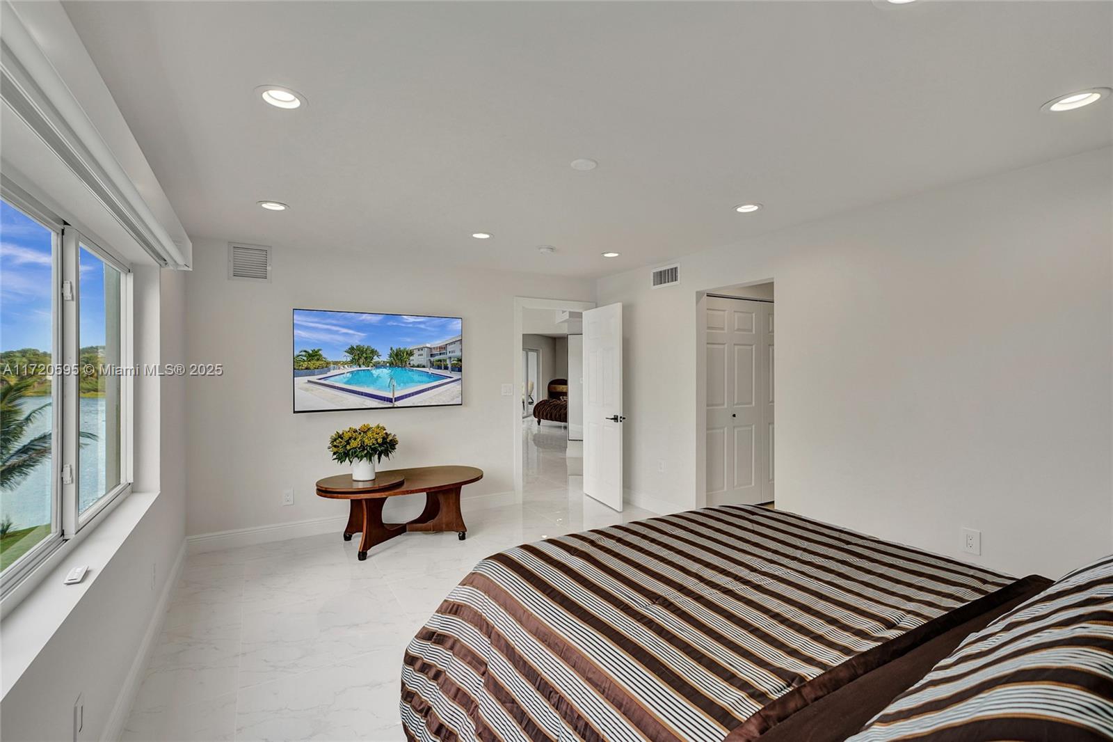 877 Northeast 195th Street, Unit 222 Miami, FL 33179 - Photo 44 of 93 a bedroom with a bed and a painting on the wall