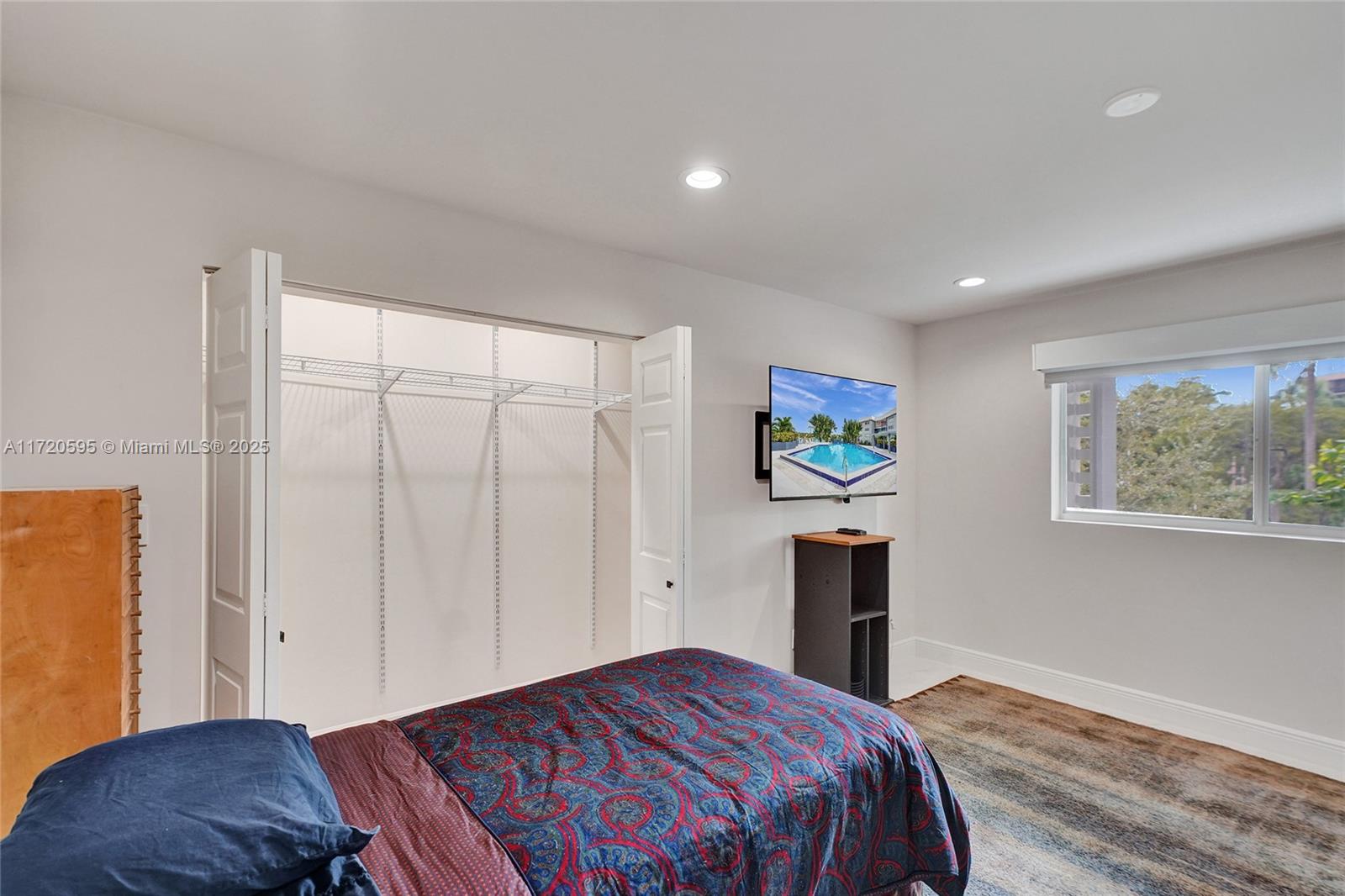 877 Northeast 195th Street, Unit 222 Miami, FL 33179 - Photo 59 of 93 a bedroom with a bed and a painting on the wall