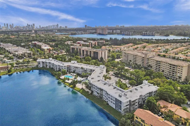 a view of kitchen island with stainless steel appliances granite countertop a sink and cabinets