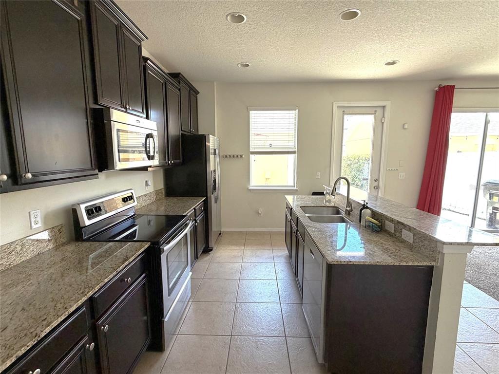 1376 Seburn Road Apopka, FL 32703 - Photo 11 of 32 a kitchen with a stove sink and microwave