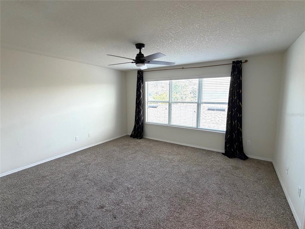 1376 Seburn Road Apopka, FL 32703 - Photo 16 of 32 an empty room with windows and chandelier fan