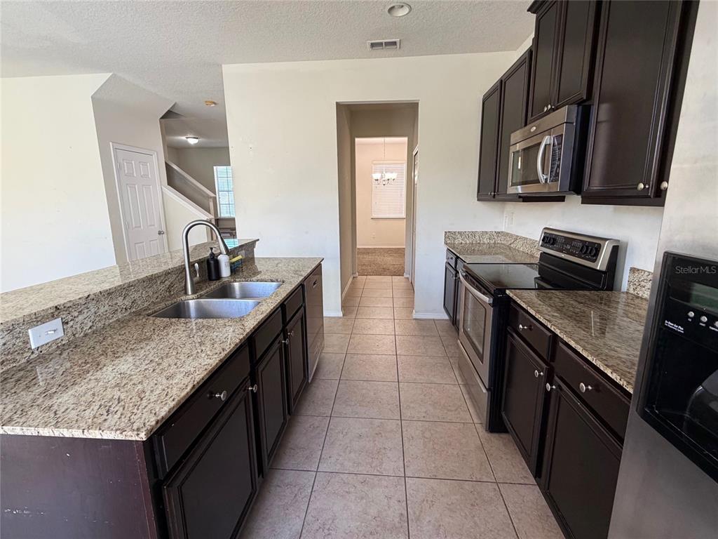 1376 Seburn Road Apopka, FL 32703 - Photo 8 of 32 a kitchen with stainless steel appliances granite countertop a sink stove and oven