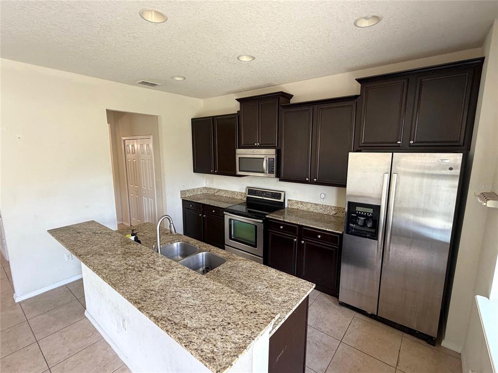1376 Seburn Road Apopka, FL 32703 - Photo 9 of 32 a kitchen with stainless steel appliances granite countertop a refrigerator and a stove