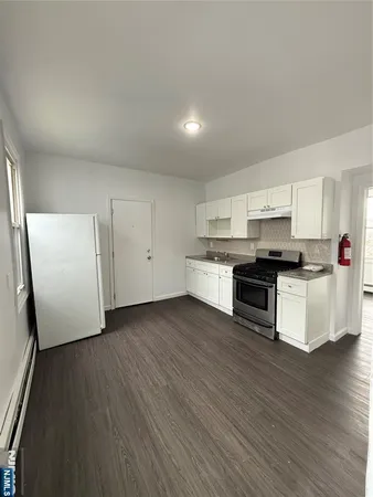a kitchen with granite countertop white cabinets and white appliances