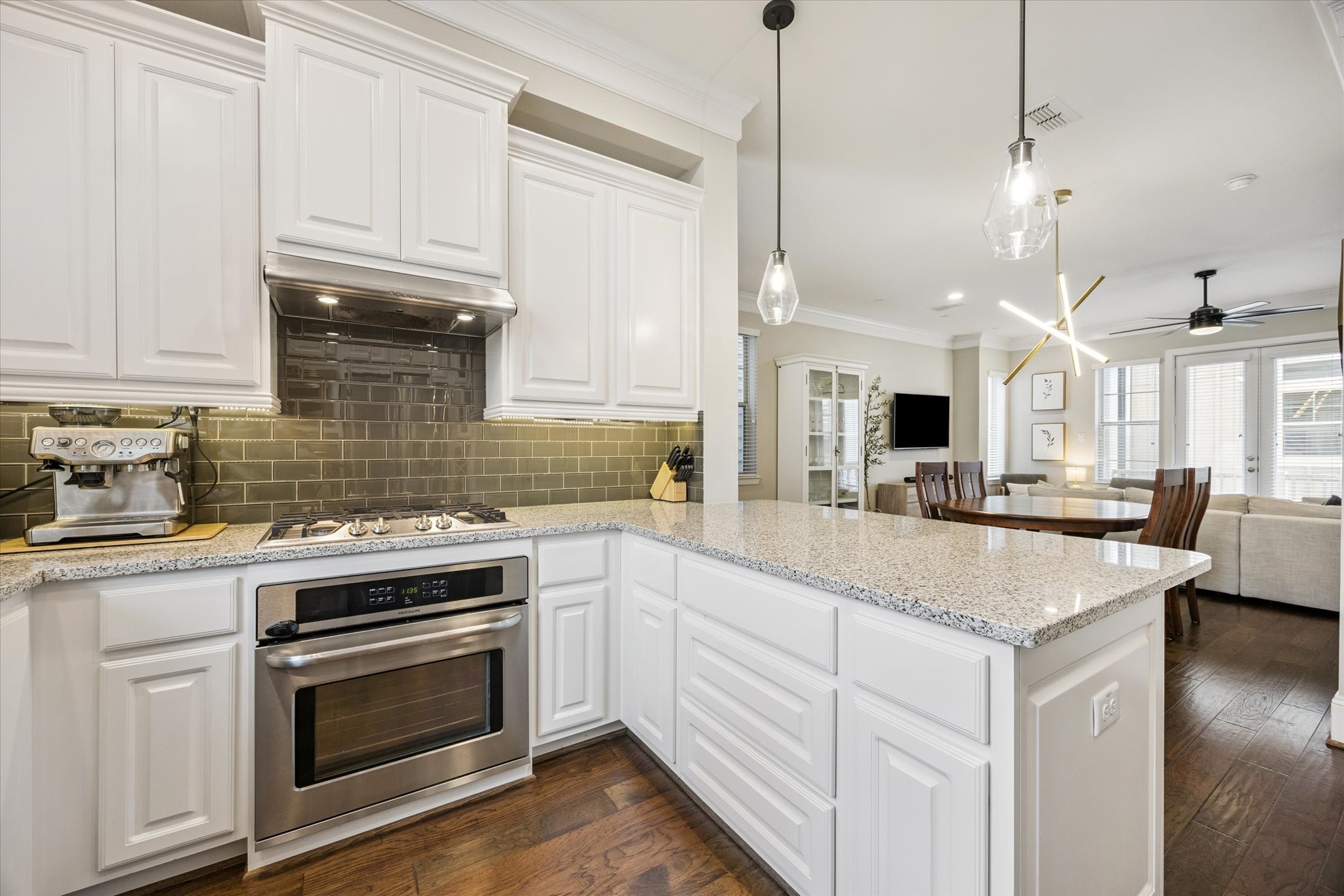 739 Dorothy Street Houston, TX 77007 - Photo 10 of 30 Framed by crisp white cabinetry, the kitchen opens beautifully to the adjacent living and dining spaces. Under-cabinet lighting highlights the glossy tile backsplash, while stainless appliances and a gas cooktop add both style and performance.