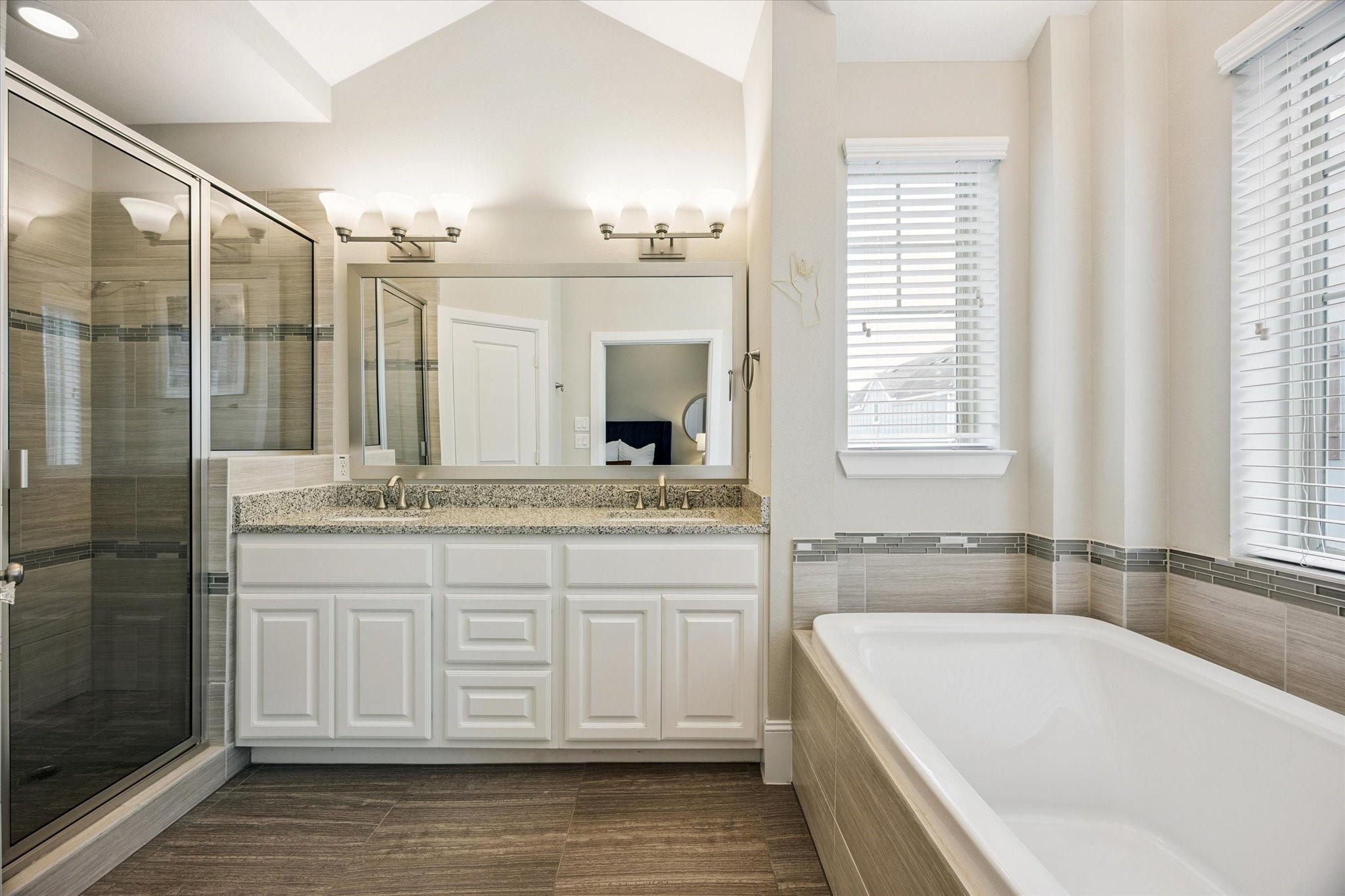 739 Dorothy Street Houston, TX 77007 - Photo 13 of 30 Spa inspired primary bath features a large soaking tub, separate glass enclosed shower, dual sinks with granite countertops, and ample natural light. A calming neutral palette and elevated ceiling complete this relaxing retreat.