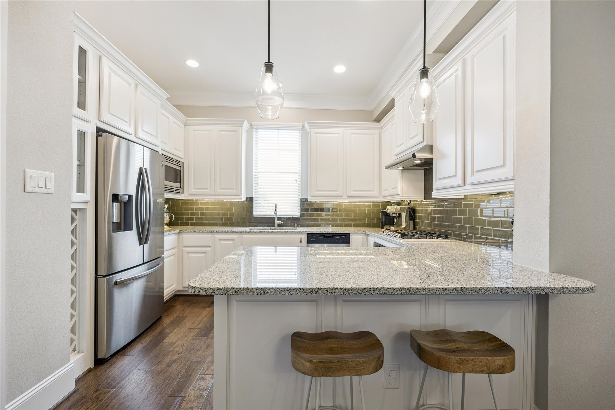 739 Dorothy Street Houston, TX 77007 - Photo 9 of 30 Bright and functional, the kitchen features granite countertops and a gas range. White cabinetry offers ample storage, while a glossy subway tile backsplash adds depth and contrast. Pendant lighting and a peninsula with seating complete the space.