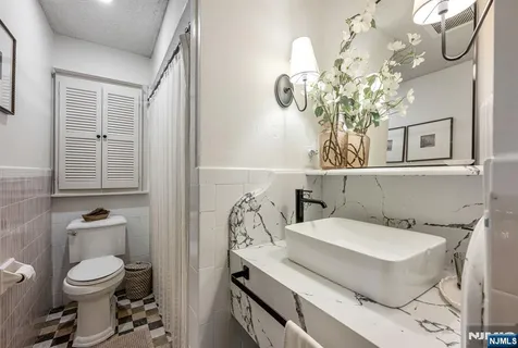 a bathroom with a sink mirror and toilet